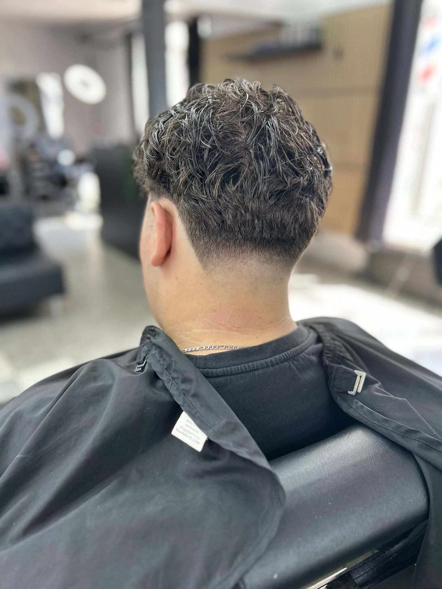 Barber giving a precise haircut to a client in a clean modern barbershop